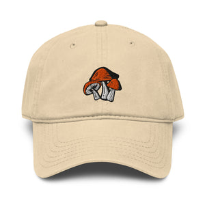 Khaki color baseball cap with graphic illustration of three mushrooms on the front. Mushrooms have orange caps and white stems.